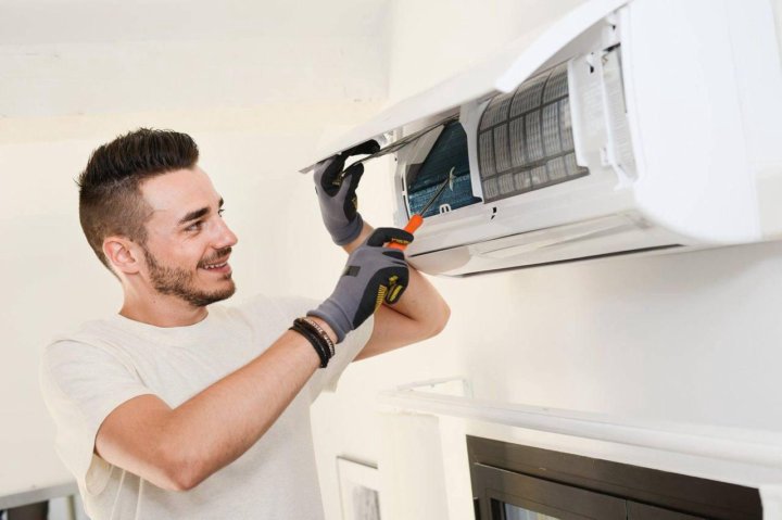 tech repairing air con