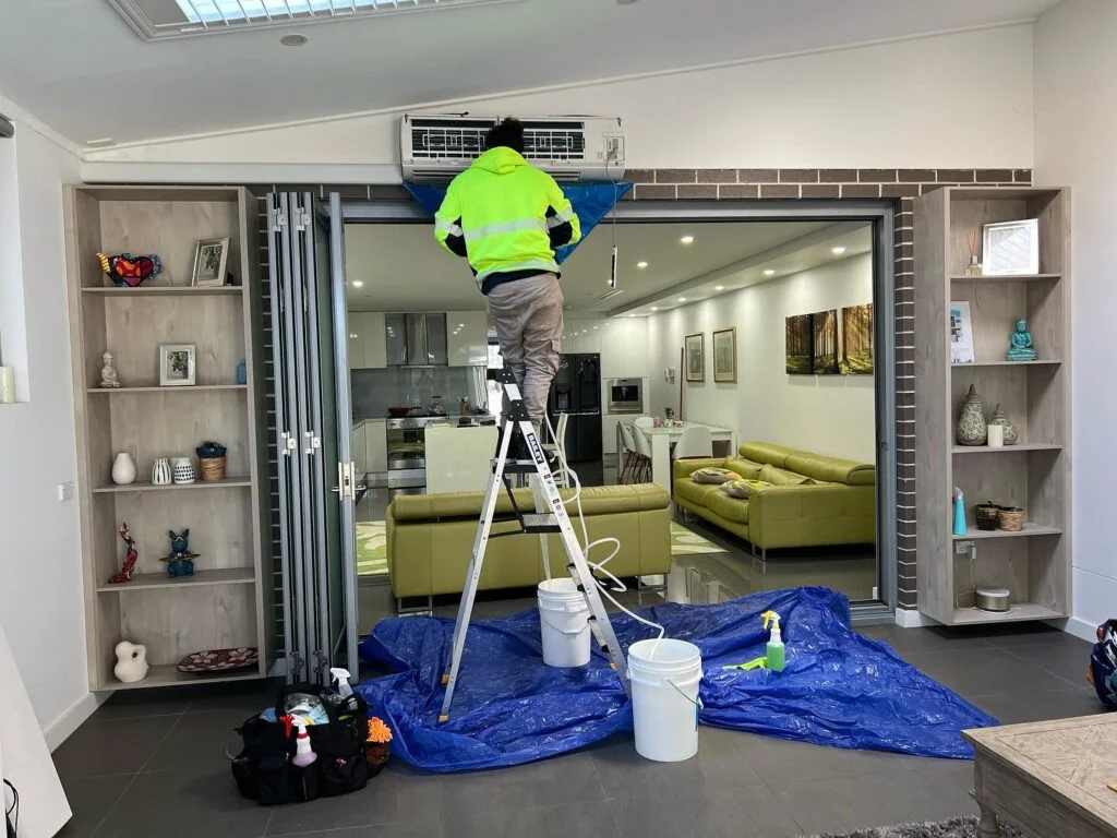 a technician cleaning a split system